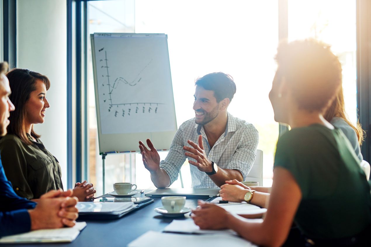 Team diskutiert in einem Meeting mit einer Flipchart, um Prozesse und Strategien für ERP Consulting zu optimieren.