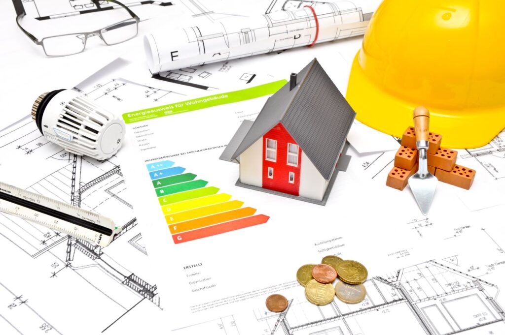 Modellhaus mit Energieausweis, Bauplänen, Thermostat, Bauhelm und Münzen – praktische Ideen mit LED-Strips für ein nachhaltiges Zuhause.