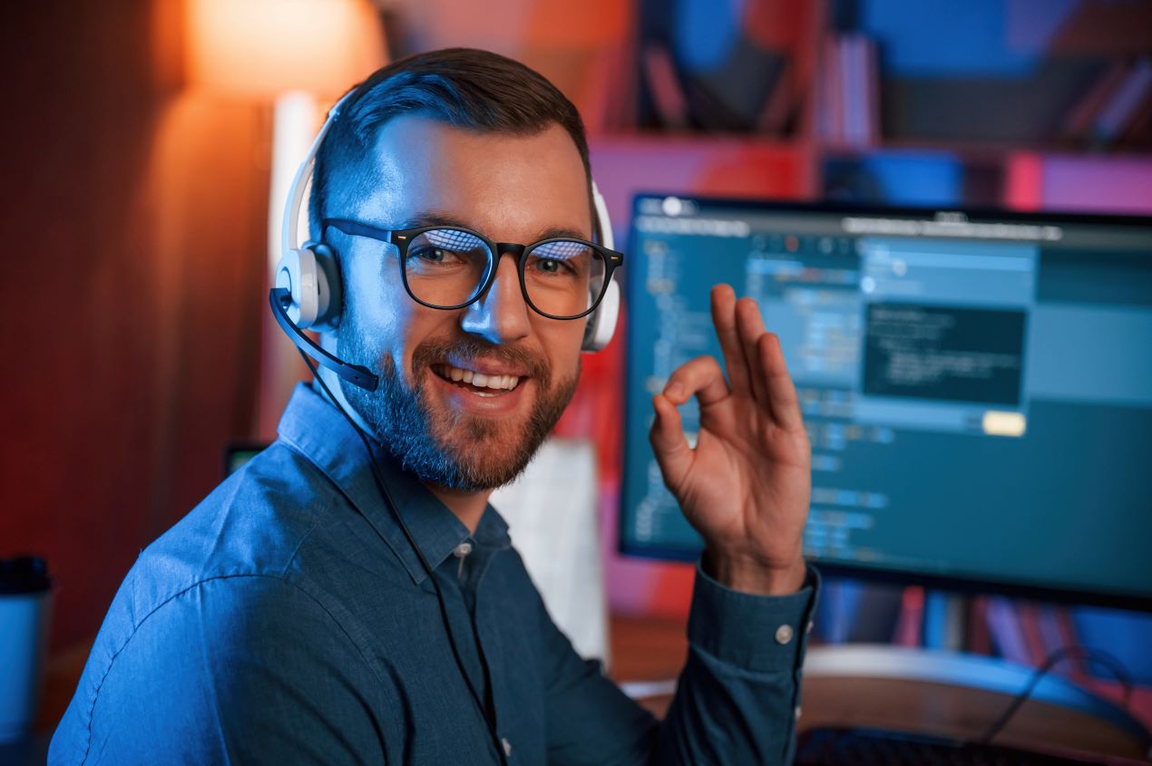 Ein IT-Experte mit Headset vor einem Monitor mit Code, ein Symbol für effektive und sichere Keycloak Hosting-Lösungen.